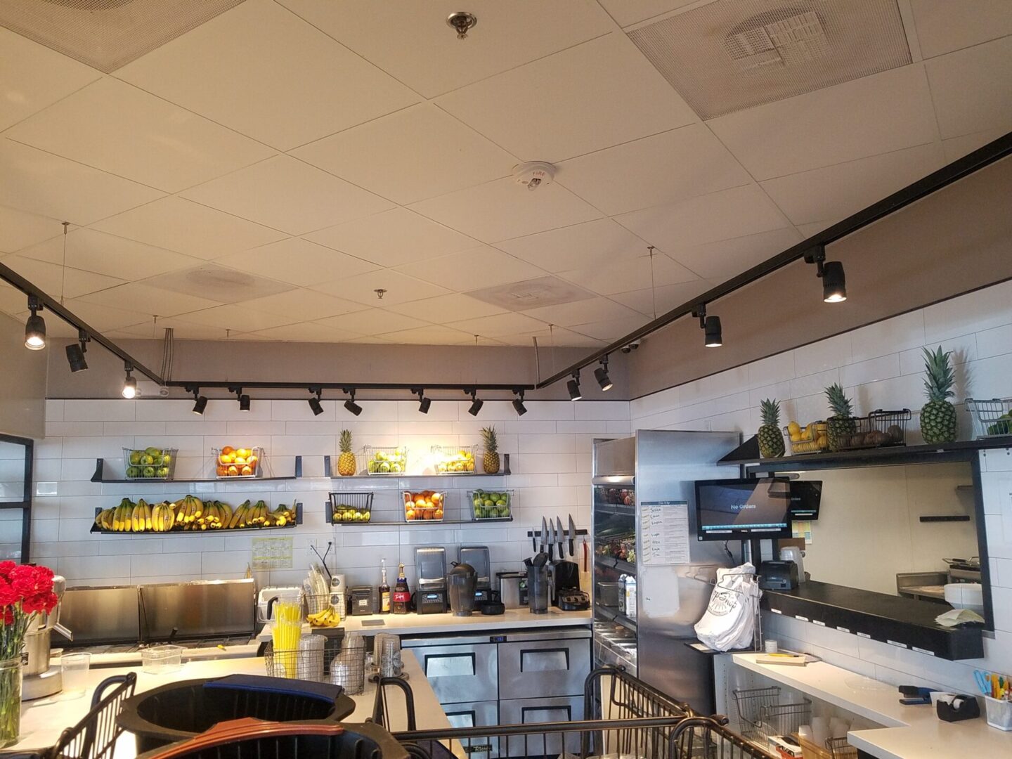 A kitchen with many shelves and lights above it