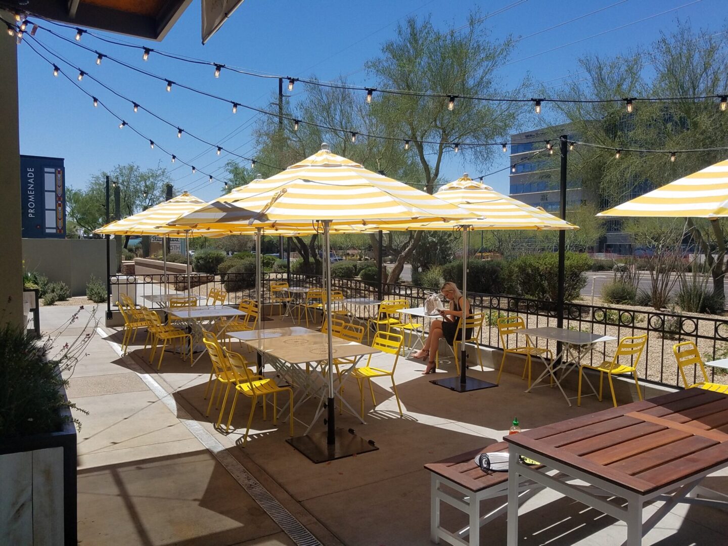 A patio with tables and chairs, yellow umbrellas.